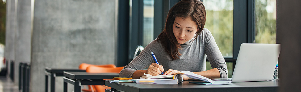 female student in library studying at table