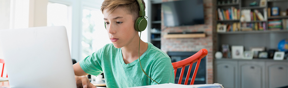 boy with headphones on laptop